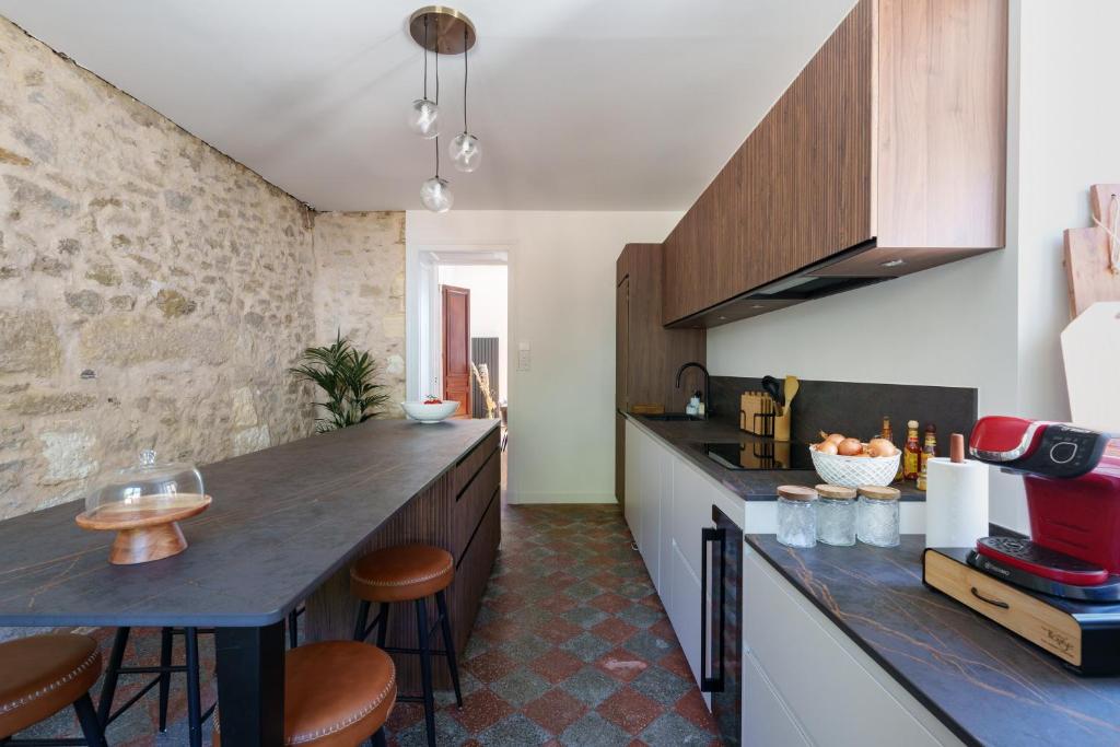 Cuisine équipée avec îlot central et mur en pierre