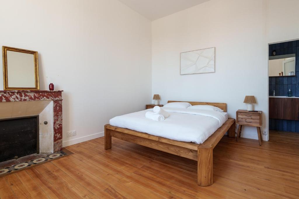 Chambre 2 avec lit en bois massif et cheminée en marbre