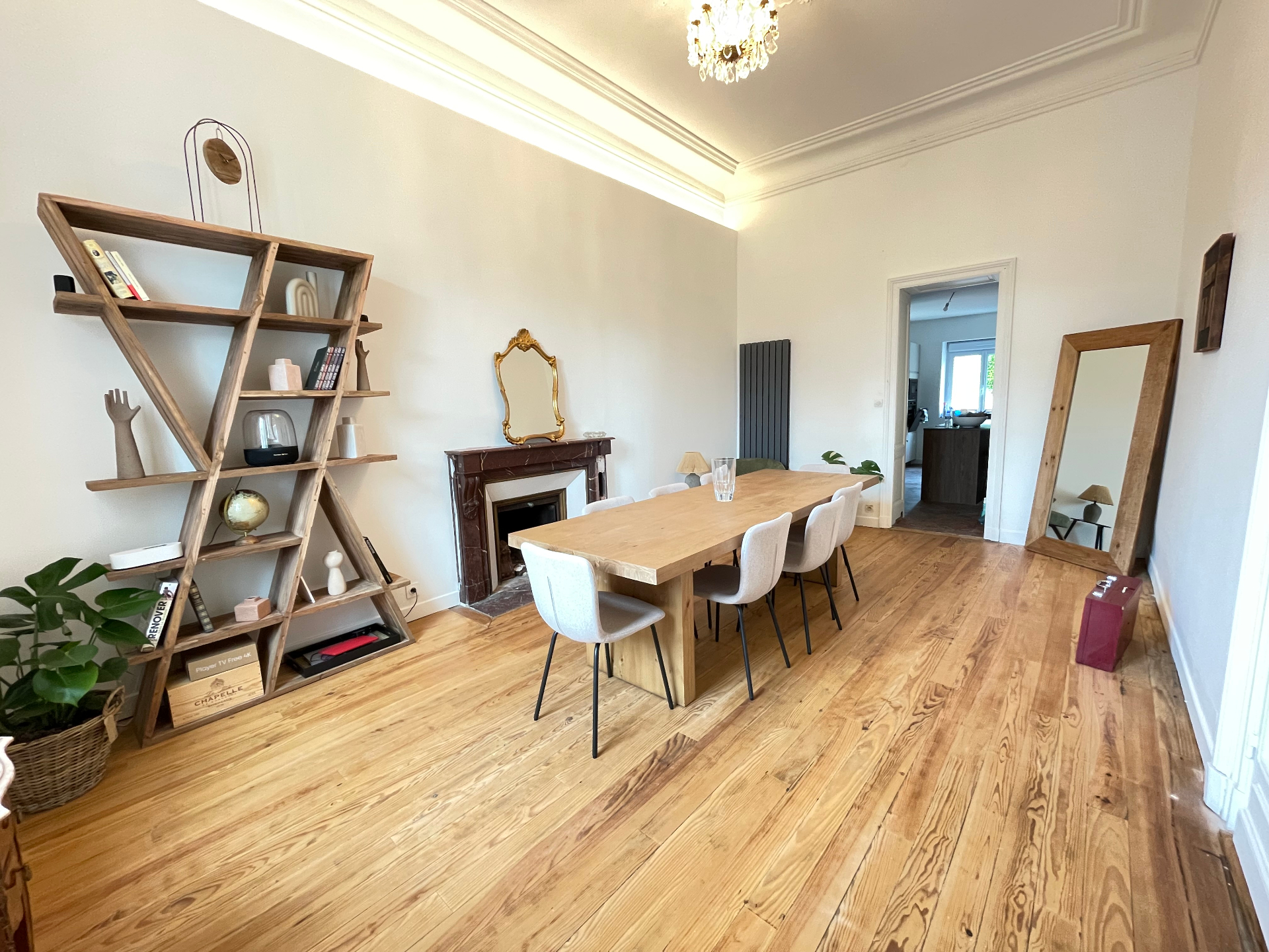 Grand salon avec poutres apparentes et mur en pierre
